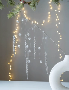 Detail view of clear acrylic icicles and crystal bead hanging on silver decorative branches