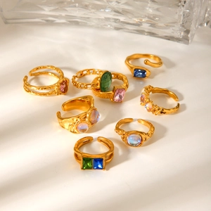 Close-up of vintage gold stainless steel rings with colorful zircon stones and textures