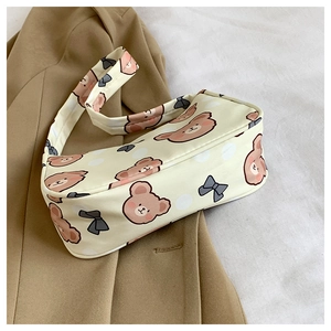 Detail of beige cartoon bear and bow print on fashionable underarm shoulder handbag