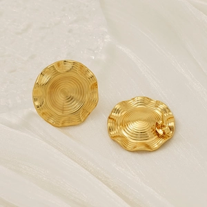 Detailed view of gold plated wavy round stud earrings with a glossy rippled metal finish