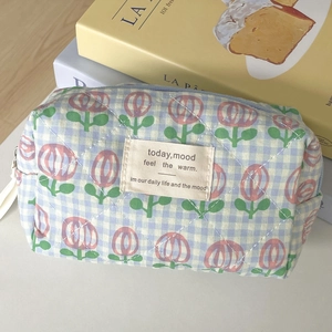 Quilted blue checkered cosmetic bag with floral print and white zipper closure