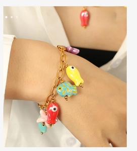 Detailed shot of ocean-themed charm bracelet with colorful sea life on a golden chain