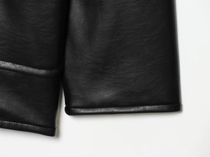 Detailed close-up of the fine texture and high-quality stitching on black leather jacket