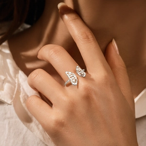Macro shot of a hollow butterfly silver ring on a finger with adjustable band detail