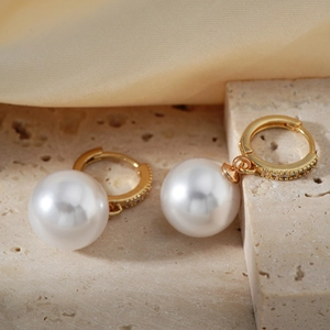 Elegant gold hoop earrings featuring large round white pearls and sparkling pavé crystals