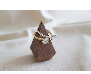 Detail view of gold and silver four-prong cubic zirconia rings on wooden pyramid display