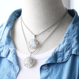 Detailed view of silver bead necklaces with moon star and tree of life opal pendants
