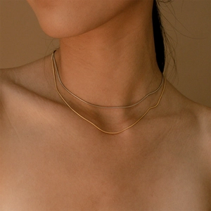 Layered gold and silver snake bone chain necklace in minimalist 18K gold plated steel
