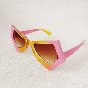 Detail of pink-yellow gradient irregular frame with brown tinted lenses on cat eye sunglasses