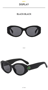 Front and 45-degree side view of black sunglasses with green teardrop crystal detail
