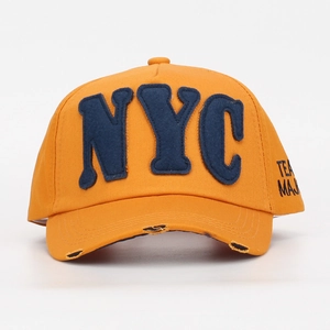 Dettaglio del cappellino arancione con ricamo NYC in feltro blu e visiera usurata