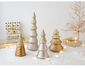 Miniature Christmas trees in metallic gold and bronze finishes on a snowy tabletop