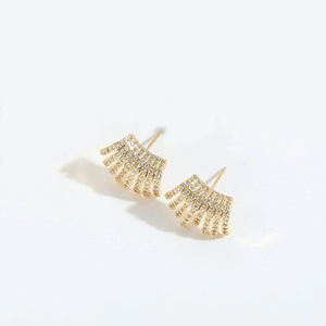 Detailed macro view of gold fan-shaped stud earrings with sparkling zircon inlay