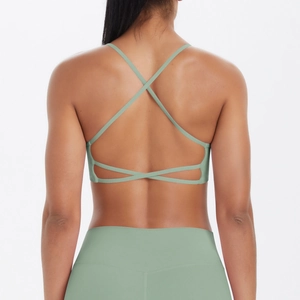 Détail du soutien-gorge de sport vert sauge avec un design sexy à bretelles croisées au dos
