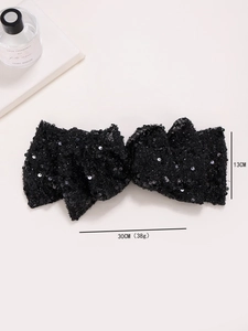 Large black sequined bow hair clip with detailed size labels 30cm by 13cm on cream base