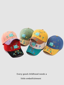 Detailed pile of colorful kids dinosaur baseball caps showing various color combinations