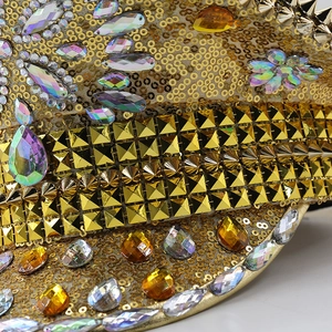 Macro detail of golden sequins and colorful rhinestones on a shiny cosplay captain hat