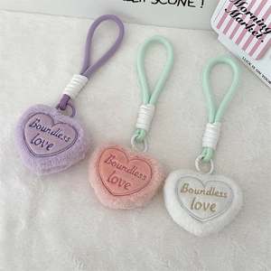 Detailed view of three plush heart keychains in pastel colors with Boundless Love embroidery