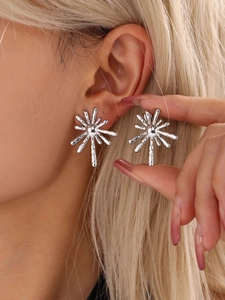 Detailed view of silver sunburst radiant earrings showing a modern textured metallic finish