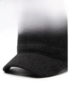 Detailed close-up of dark grey wool fabric and silver mountain badge on a flat top cap