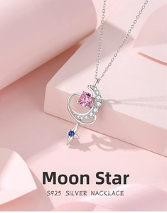 Macro detail of S925 silver moon and star pendant featuring pink and blue gemstones