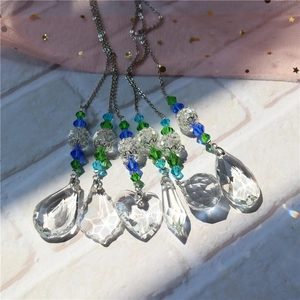 Detail of multi-shaped faceted crystals with colorful beads reflecting rainbows on mesh
