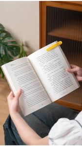 Yellow silicone book page holder for reading, close-up of stable clip on a book page