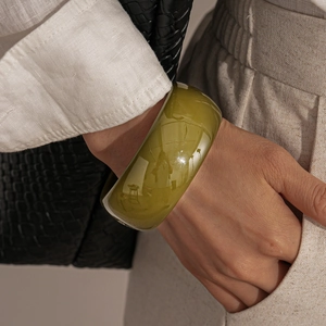 Close-up of olive green acrylic chunky round bangle with glossy vintage resin texture