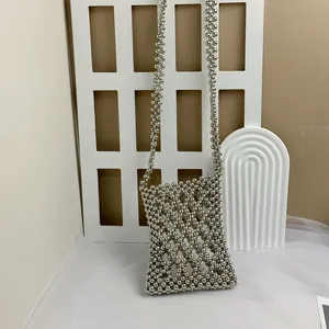 Detail of silver beaded crossbody bag featuring an openwork grid weave design