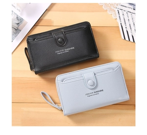 Close-up of black and light blue textured leather long wallets with wrist straps and zippers
