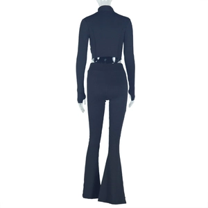 Rear view of black ribbed knit two-piece set with long sleeve crop top and flared pants