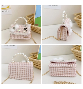 Detail view of pink houndstooth wool girl bag with pearl handle and bow charm