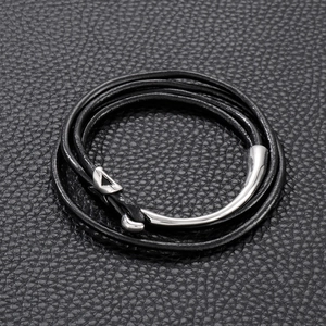 Macro shot of double-wrap black leather bracelet featuring a polished silver fishhook clasp