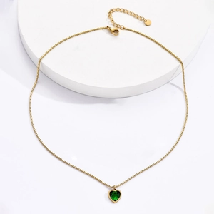 Detalle de un collar de cadena veneciana dorada con un colgante de circonita verde corazón