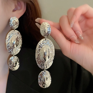 Exaggerated silver geometric earrings with hammered texture and long tassel-style circles