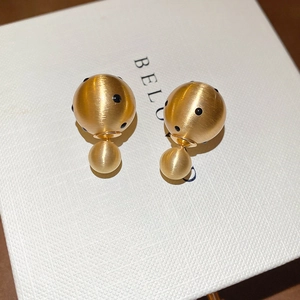 Macro shot of 18k gold plated double bead earrings with black polka dots and matte finish