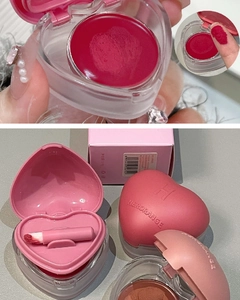 Detailed macro view of heart-shaped lip mud cases with creamy texture and mini lip brushes