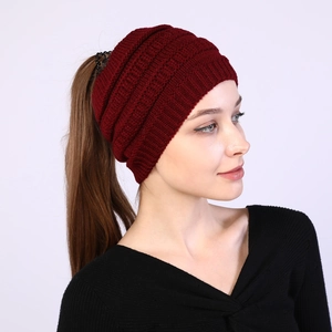 Detail view of burgundy knitted headband with back opening for high ponytails