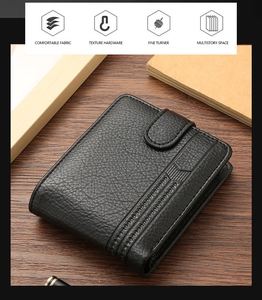 Detail of black pebbled leather men's wallet with vertical stitching on wooden background