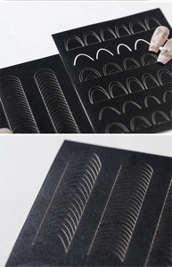 Close-up of golden French nail art stickers with various curved lines and edge stencils