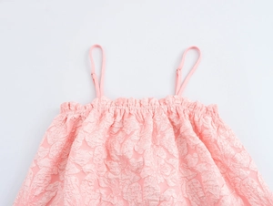 Dettaglio del top rosa con texture floreale a rilievo e spalline regolabili