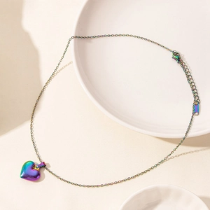 Macro shot of 18k vacuum plated iridescent heart pendant on fine stainless steel chain