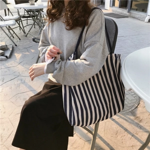 Side view of large striped canvas tote bag showing its natural drape and navy white pattern