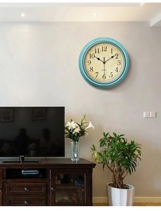 Detail of turquoise vintage wall clock with Arabic numerals on a modern living room wall