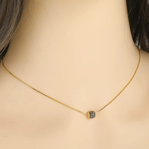 Detailed close-up of a golden box chain necklace with a blue pavé zircon spherical pendant