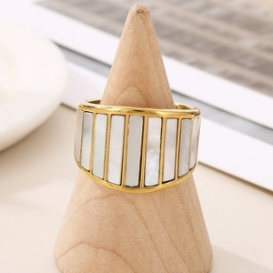 Detail of wide gold band ring featuring vertical white mother of pearl inlay on a stand