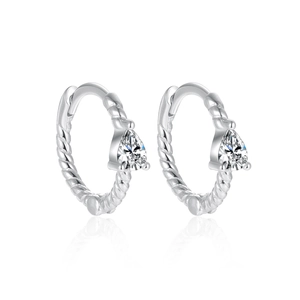 Macro view of twisted rope texture silver hoop earrings with pear-shaped zircon stones