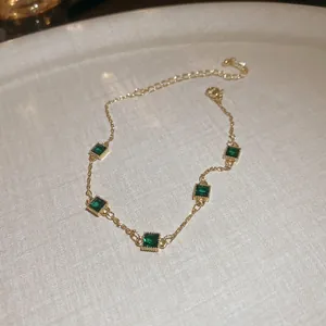 Bracelet élégant plaqué or avec cinq pierres vert émeraude carrées et chaîne ajustable