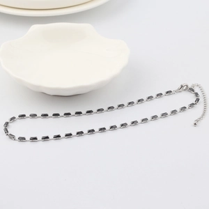 Detail of silver necklace with black rectangular zircon gems and adjustable lobster clasp