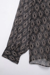 Detailaufnahme des Paisley-Musters auf Manschette und Saum der Chiffon-Bluse